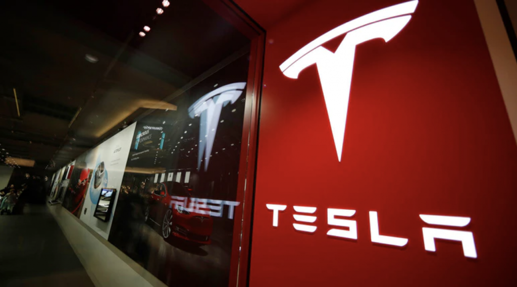 Obrazek przedstawia logo firmy Tesla, czyli producenta auta elektrycznego, o którym jest artykuł.
