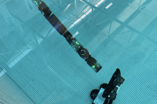 Obrazek przedstawia robota HUMRS z Carnegie Mellon University podczas testów pływania.
