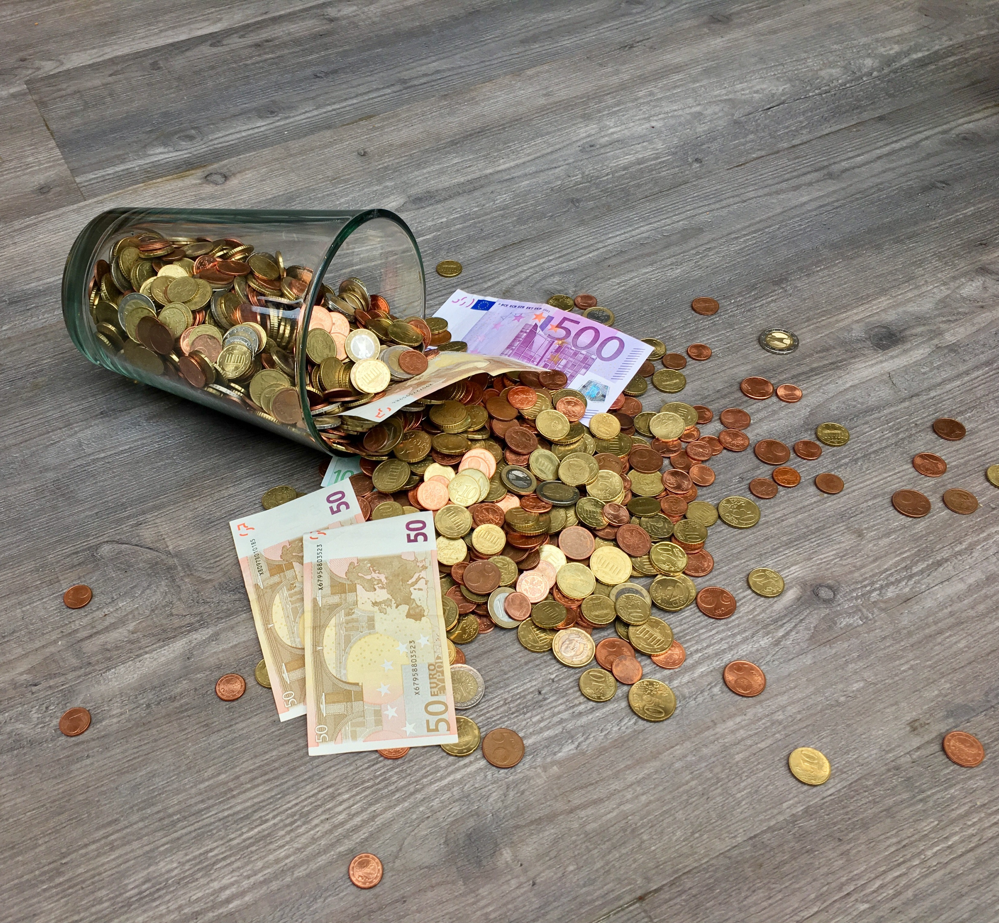 szklanka z monetami i banknotami w euro